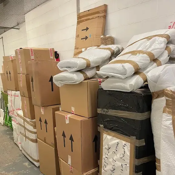Wrapped furniture, padded legs and flat cartons stacked together